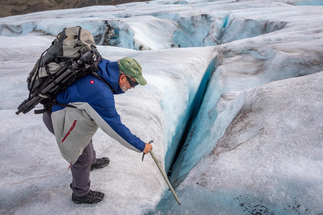 USask researcher John Pomeroy is pictured observing a crevasse on the Athabasca Glacier in the Canadian Rockies. (Photo: Sam Baardman)